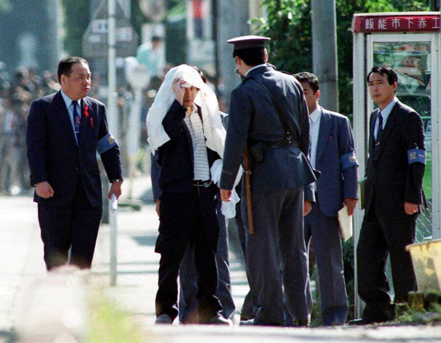 Tsutomu Miyazaki (L) at an inspection of a murder case as he was convicted of killing four young girls