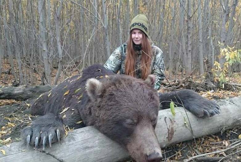 Alexandra posing with an enormous bear she shot